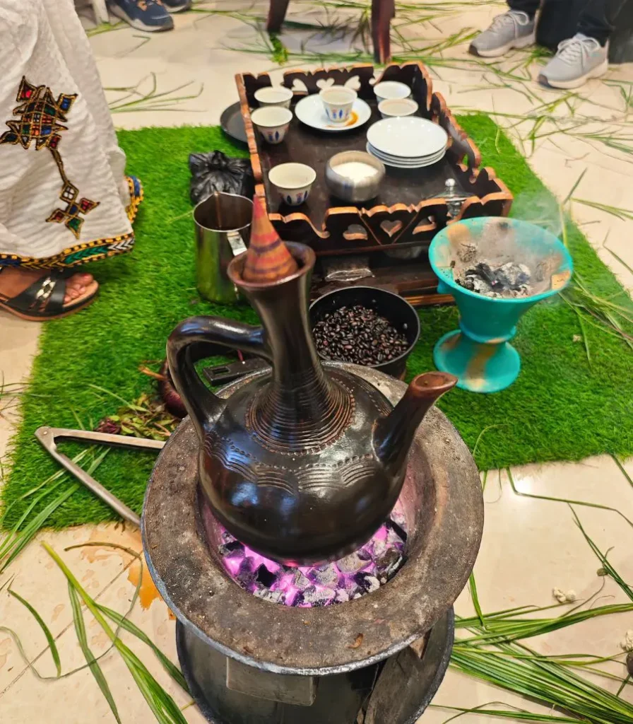 ethiopia-coffee-xploristas Τελετή καφέ στην Αιθιοπία με την παραδοσιακή πήλινη καφετιέρα πάνω στα κάρβουνα, φλιτζανάκια σε ξύλινο δίσκο, λιβάνι που καίει και φρέσκο γρασίδι στο πάτωμα